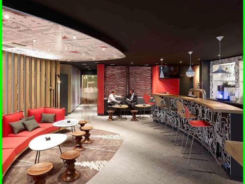 two people sitting at a bar in a restaurant at ibis Köln Centrum in Cologne