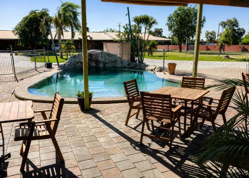 un tavolo e delle sedie accanto a una piscina di Boulder Opal Motor Inn a Winton
