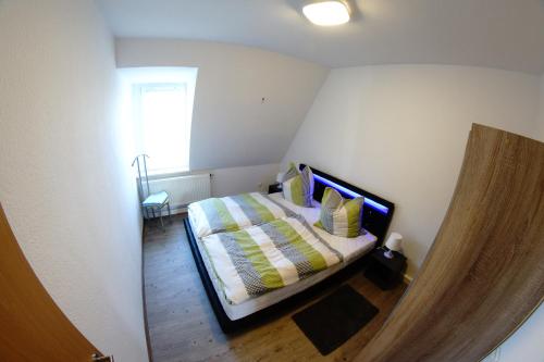 a bedroom with a bed with yellow and green pillows at FEWO Leipzig-Plagwitz in Leipzig
