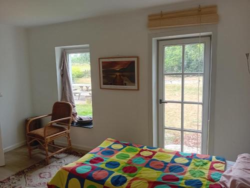 a bedroom with a bed and a chair and a window at Kamer in Fermette Vlaamse Ardennen in Maarkedal