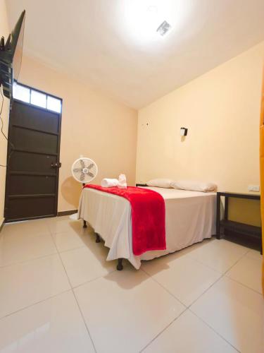 a room with a bed with a red blanket on it at Guadalupe House Esquipulas in Esquipulas