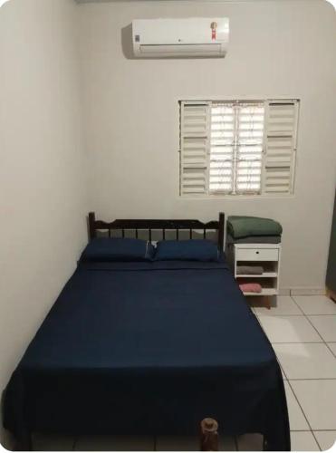 a bedroom with a blue bed and a window at Rancho do Véio in Aquidauana