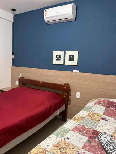 a bedroom with a bed and a air conditioner on a blue wall at Garden em Guarajuba in Tareco