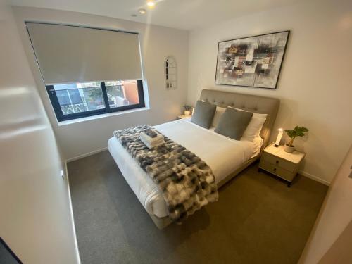 a bedroom with a large bed and a window at Central City Views In Heart of Central Chch by Stadium in Christchurch