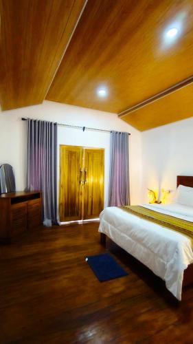 a bedroom with a large bed and a wooden ceiling at Dom Dom Guest House Gili Gede in Gili Gede