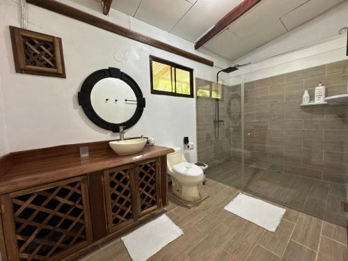a bathroom with a sink and a toilet and a mirror at Arrecife Punta Uva - Hospedaje, bar y restaurante - Frente al mar in Punta Uva