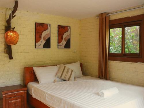 a bedroom with a bed and two pictures on the wall at căn 3 ngủ in Ấp Tân Long