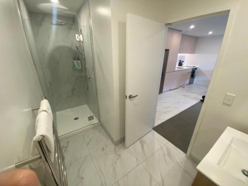a bathroom with a walk in shower and a sink at Central City Views In Heart of Central Chch by Stadium in Christchurch