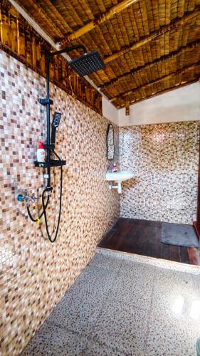 a room with a bench in a brick wall at Dom Dom Guest House Gili Gede in Gili Gede