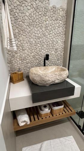 a bathroom with a stone sink on a counter at Casa GERIBÁ in Búzios