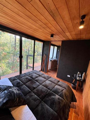 a bedroom with a large bed and a large window at Disfruta del Bosque in Mazamitla