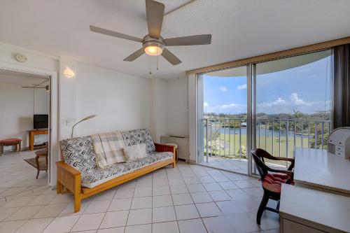 a living room with a couch and a ceiling fan at Hilo Lagoon Centre - 4BR Condos - Sleeps 12 in Hilo