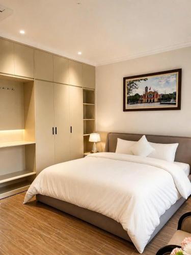 a bedroom with a large white bed with a picture on the wall at Annava Hotel & Coffee in Hai Phong