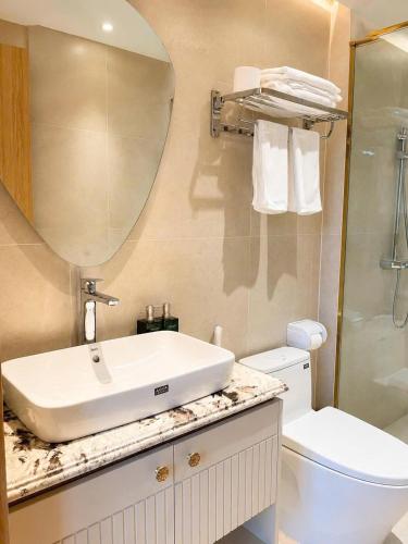 a bathroom with a sink and a toilet and a mirror at Annava Hotel & Coffee in Hai Phong
