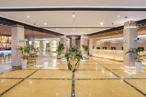 a lobby with potted plants in a building at Meliá Alicante in Alicante