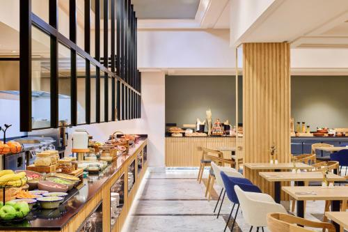a restaurant with a buffet of food and tables at Meliá Maria Pita in A Coruña