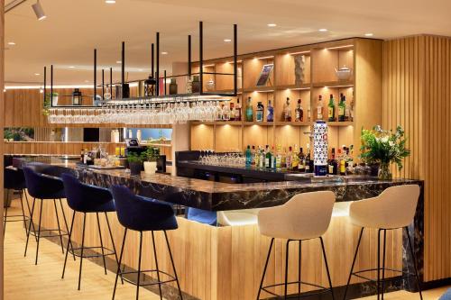 a bar in a hotel room with stools at Meliá Maria Pita in A Coruña