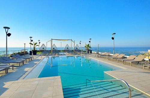 a swimming pool with chairs and the ocean in the background at Meliá Costa del Sol in Torremolinos