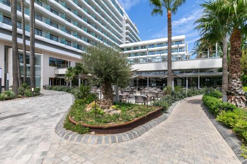 a courtyard in front of a building with palm trees at SOL by Meliá Torremolinos Don Pablo in Torremolinos