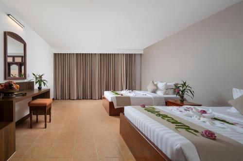 a hotel room with two beds and a mirror at THE RIVERFRONT CENTRAL Hotel in Siem Reap