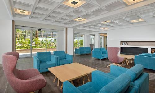 a waiting room with blue chairs and a table at SOL by Meliá Torremolinos - Don Pedro in Torremolinos
