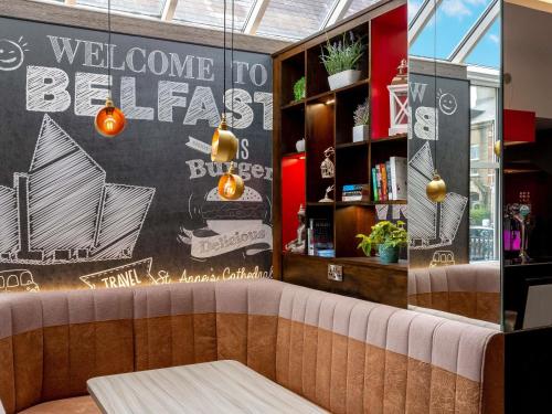 a restaurant with a wall with a welcome to berlin sign at ibis Belfast Queens Quarter in Belfast