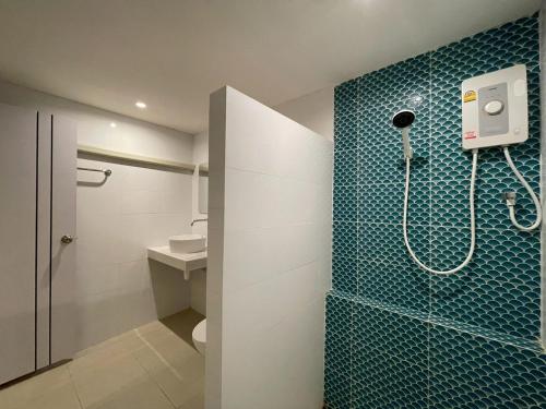 a bathroom with a shower with blue tile on the wall at Naiharn On The Rock Resort Phuket in Nai Harn Beach