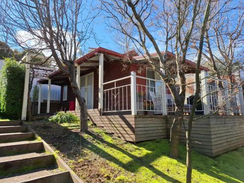 a house with a porch and a balcony at Bella Rouge Cottage in Bright