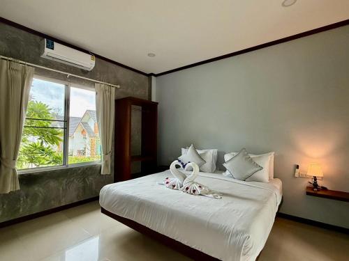 a bedroom with a bed with two stuffed animals on it at The Rinya Hotel Koh Phangan in Thong Sala