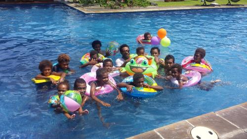 a group of children in a swimming pool at Rapopo Plantation Resort in Kokopo