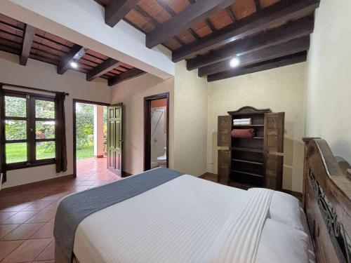 a bedroom with a large bed and a bathroom at Alana Hotel By ISH in Antigua Guatemala