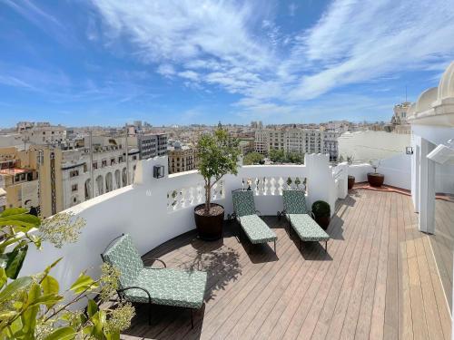 a balcony with chairs and a view of a city at Meliá Plaza Valencia in Valencia