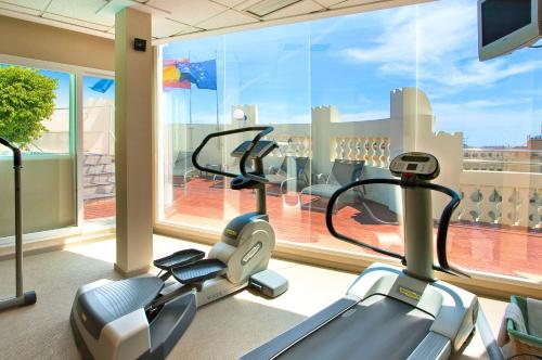 a gym with two cardio machines in front of a large window at Meliá Plaza Valencia in Valencia