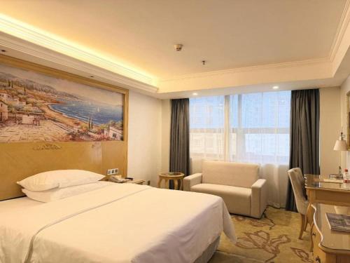 a hotel room with a bed and a chair at Guangna Hotel in Huizhou