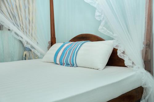 a bed with a canopy and a white pillow at veranda guest home in Mirissa