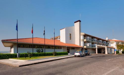 a building with a car parked in front of it at Meliá Castelo Branco in Castelo Branco