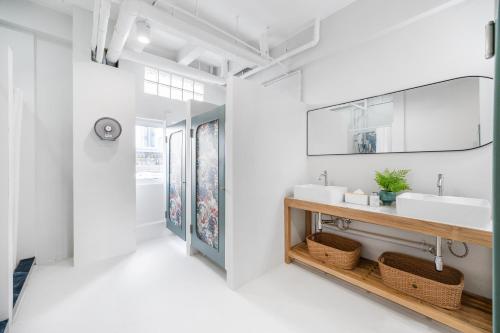 a bathroom with two sinks and a mirror at Unplugged at Bangrak & Silom Design Hostel in Bangkok
