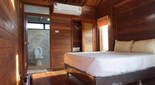 a bedroom with a bed and a bathroom with a toilet at Hotel Golf 19 in Ban Hua Khao
