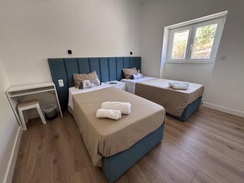 a room with two beds and a tv in it at Refúgio Templário in Pedreira