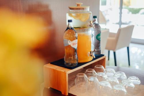 a table with two bottles of orange juice and glasses at Meliá Setúbal in Setúbal