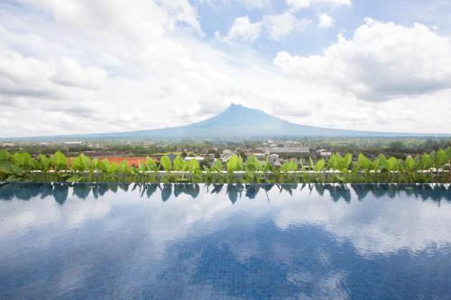 a view of a mountain with a reflection in a lake at INNSiDE by Meliá Yogyakarta in Yogyakarta