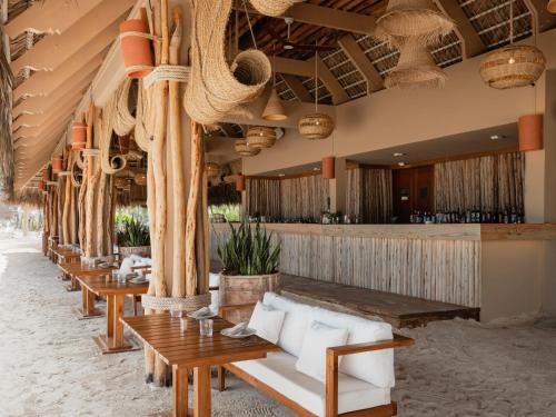 a restaurant with a row of tables and a bar at Zel Punta Cana - All Suites - All Inclusive in Punta Cana