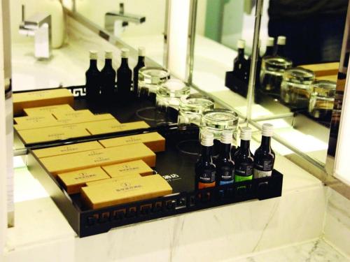 a counter with bottles of wine and wine glasses at Harbin Splendent Hotel in Shuangcheng