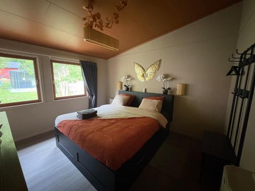a bedroom with a bed with a butterfly on the wall at Hytter Brokefjell in Kviteseid