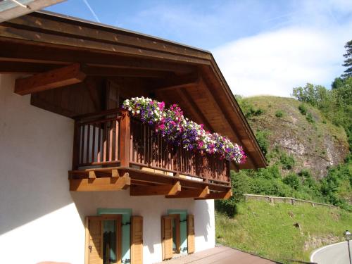 a balcony with flowers on the side of a building at B&B El Molin in Cavalese