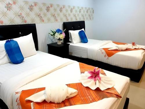 a hotel room with two beds with flowers on them at Baanthanthip in Khon Kaen