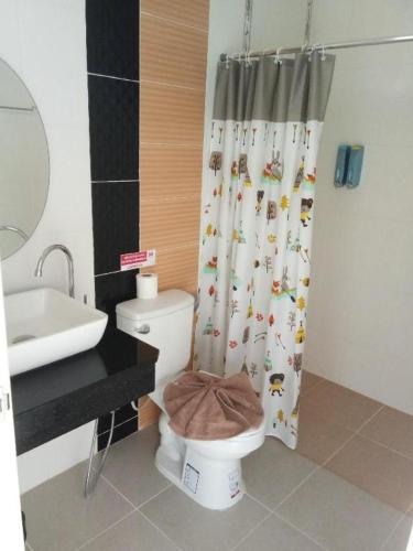 a bathroom with a toilet and a shower curtain at Baanthanthip in Khon Kaen
