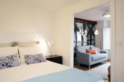 a bedroom with a bed and a blue chair at Alfama Apartment with River view in Lisbon
