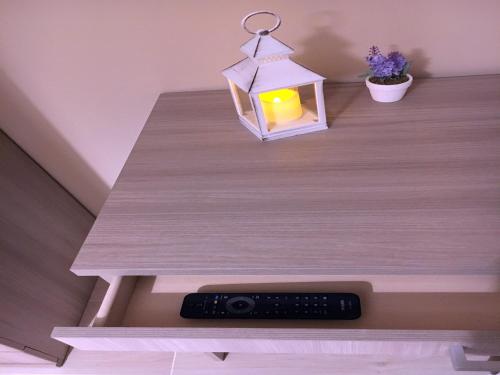 a candle in a lantern on a table with a remote control at B&B Rossini in Vieste