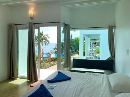 a bedroom with a bed and a view of the ocean at Naiharn On The Rock Resort Phuket in Nai Harn Beach